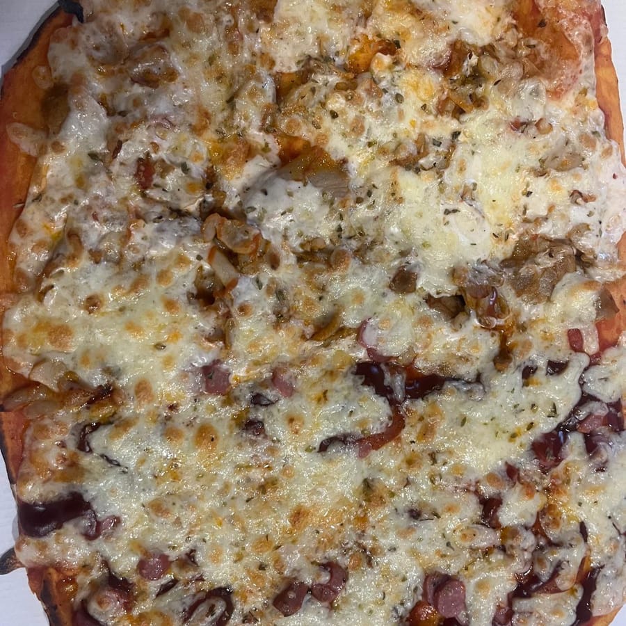 Pizza artesana de WOW Pizzería Fuente Palmera recién sacada del horno con albahaca fresca y mozzarella